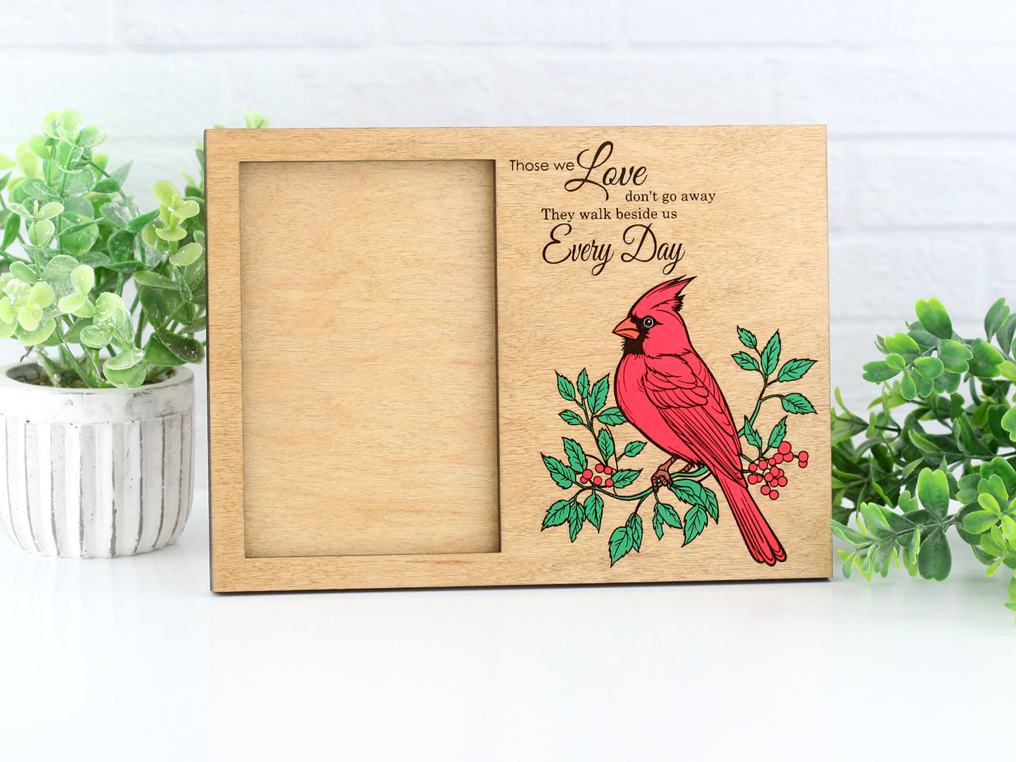 Wooden picture frame with a red cardinal design and engraved text on a white background.