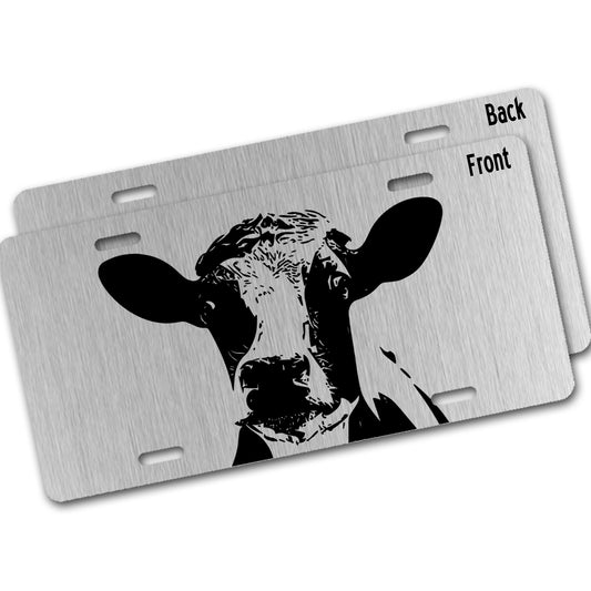 Metal license plate with a cow design  on a silver background