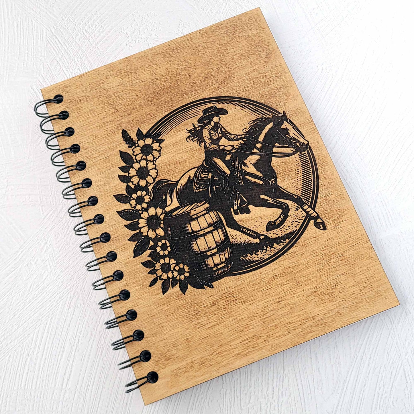Wooden notebook with a barrel racer and horse design on a white background