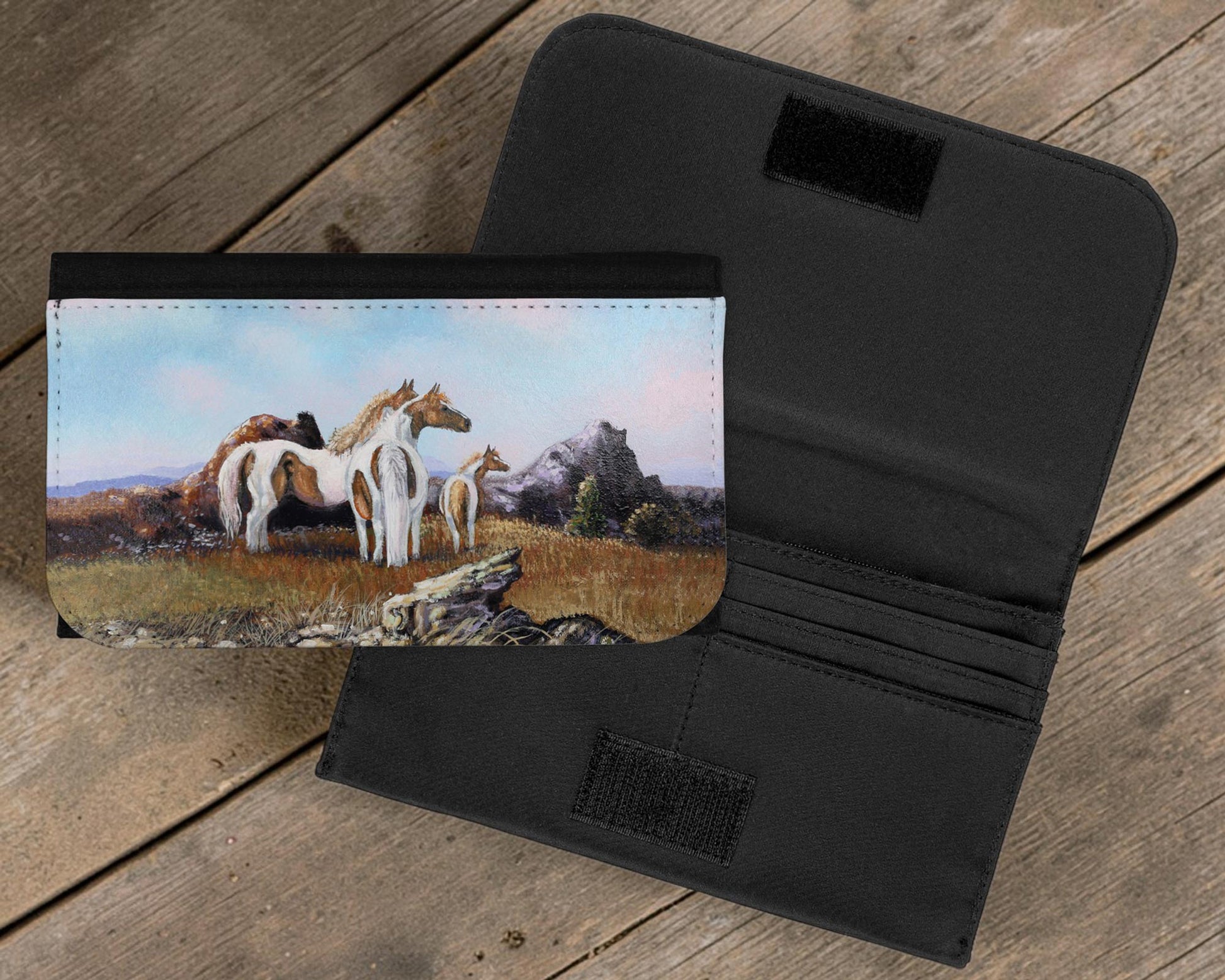 Black wallet with horse painting on a wooden surface