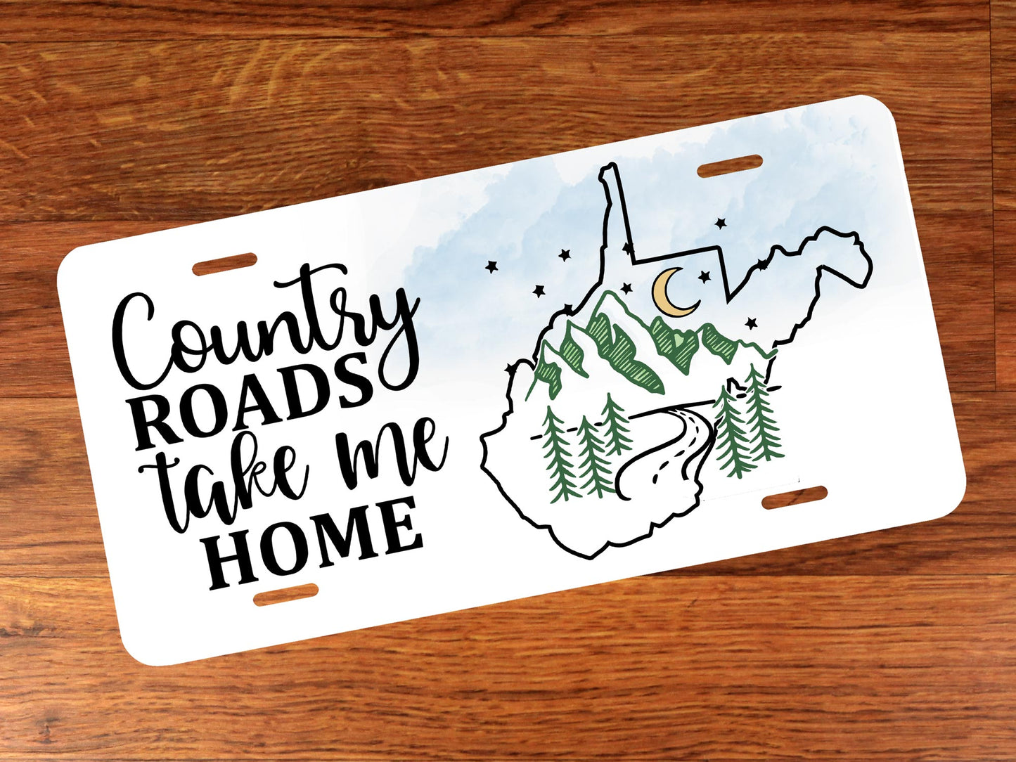 License plate with 'Country Roads take me Home' text and a map design on a wooden surface