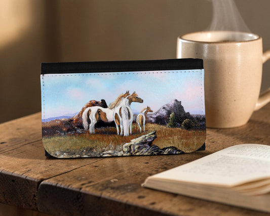 Long wallet with horse design on a wooden surface next to a cup of coffee and book